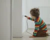 Child sitting on the floor and plugin a cable
